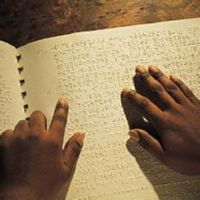 Photograph of braille being read by 2 hands