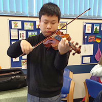 Photo of Zheyuan at SRSB playing violin