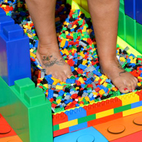 Photo of someones feet walking on lego pieces