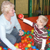 Photo of a young SRSB client playing in a ball pool