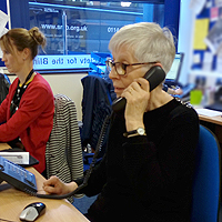 Photograph of a volunteer speaking on the phone in the office