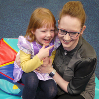 Photograph of one of SRSBs young clients with her mum