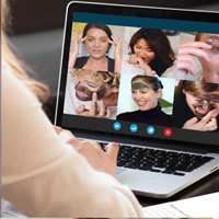 Photo of someone looking at a screen with people applying facemasks