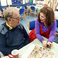 Photo of two people chatting over a cup of tea