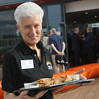Photo of a volunteer with a tray of food at an event