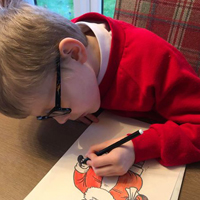 Photo of a young boy colouring a picture