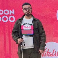 Bilaal in front of a banner