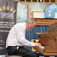 Photo of Bill at Victoria Hall playing the piano