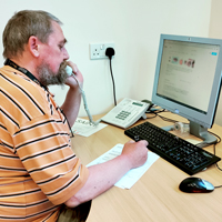 Photo of one of our CAOs on the telephone filling in a form