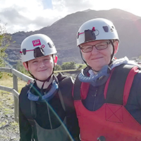 Photo of Jenny with her son at the 2022 zip line, both wearing helmets