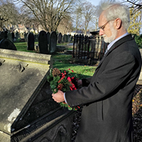 Photo of Steve Hambleton placing the wreath on Eliza's grave
