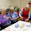 Photograph of clients and volunteer in craft room