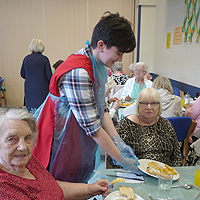 Photo of a volunteer with clients in the activities centre